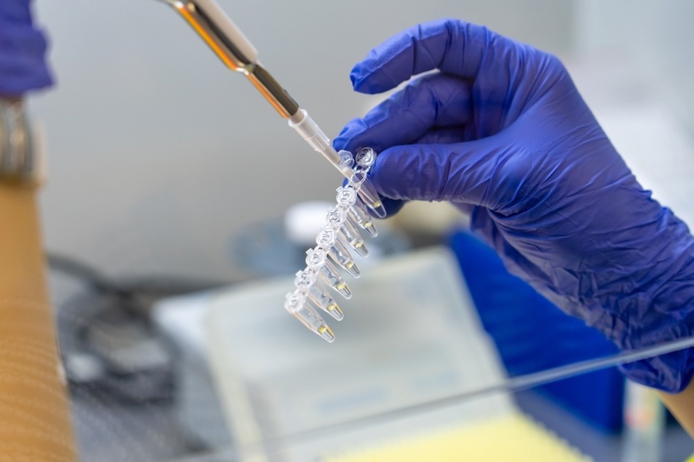 scientists pipetting sample of DNA