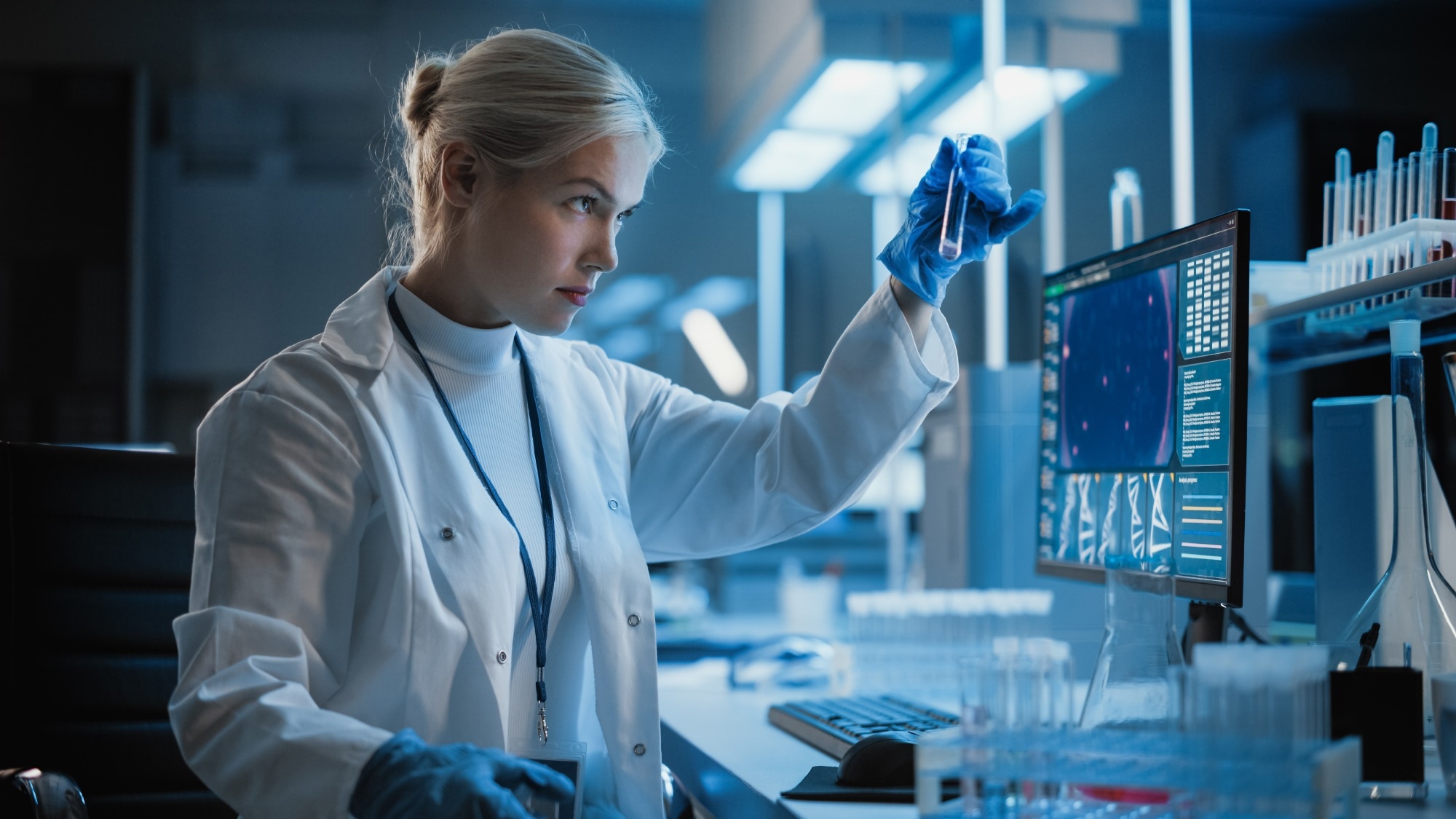 Portrait of Female Scientist Working on Computer, Analysing Liquid Sample in a Laboratory Flask