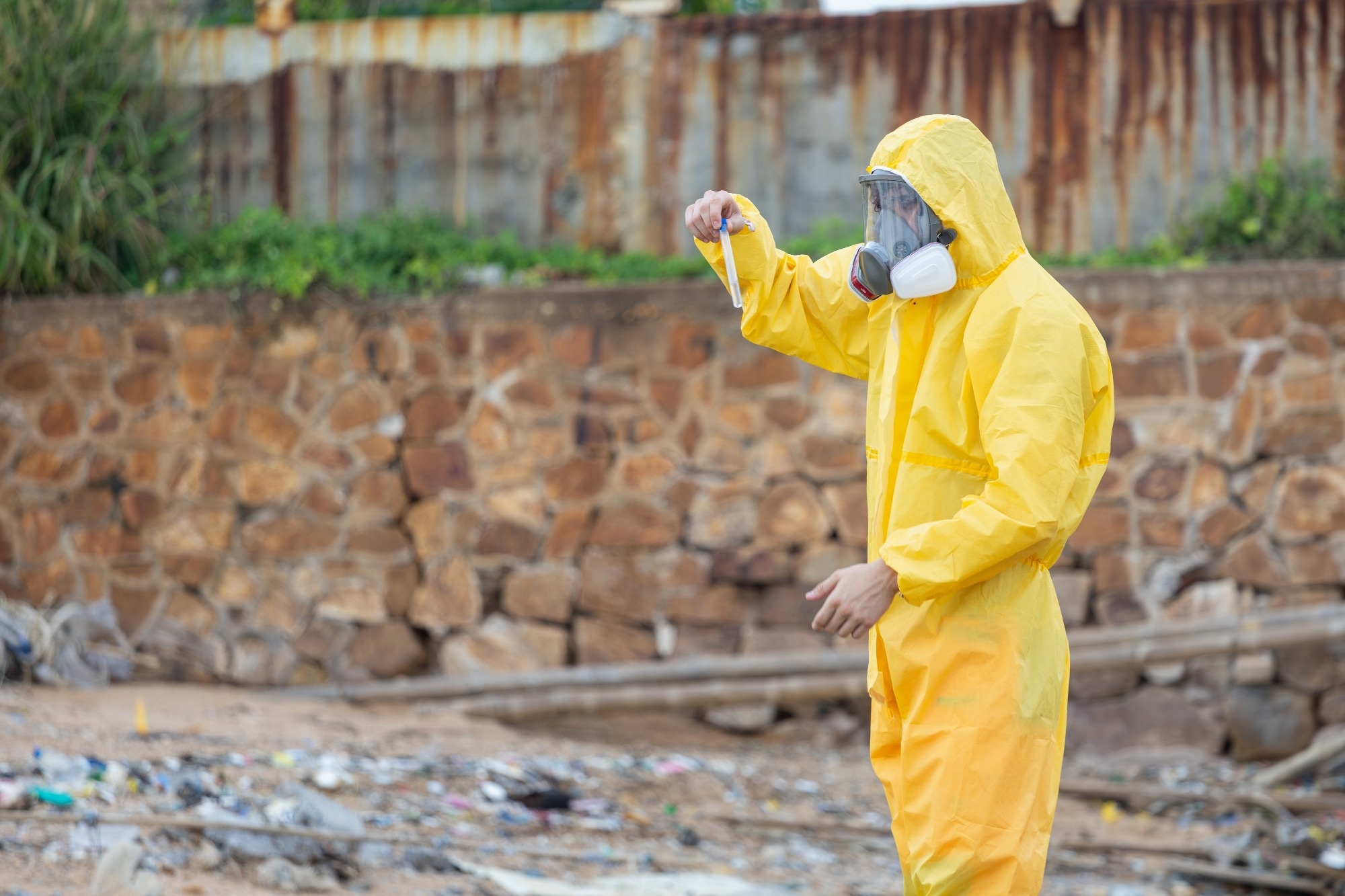 Environmental Scientist in Hazmat Suit Collecting Sample at Contaminated Site