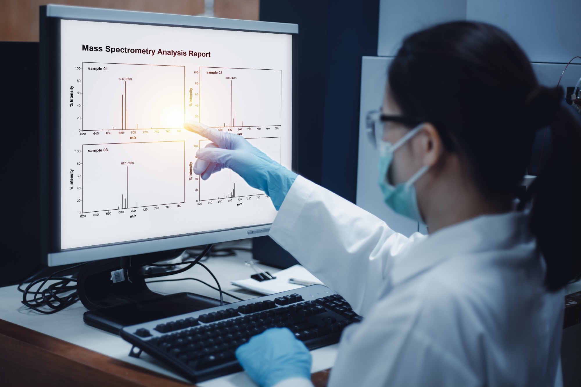 Scientist woman indicates the chromatogram of mass spectrometry analysis results of compounds, as shown on the computer monitor of mass spectrometer instrument in the laboratory