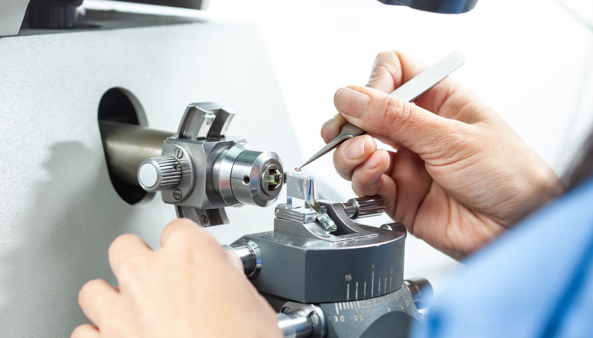 A scientist places a sample onto a transmission electron microscopy grid for analysis.