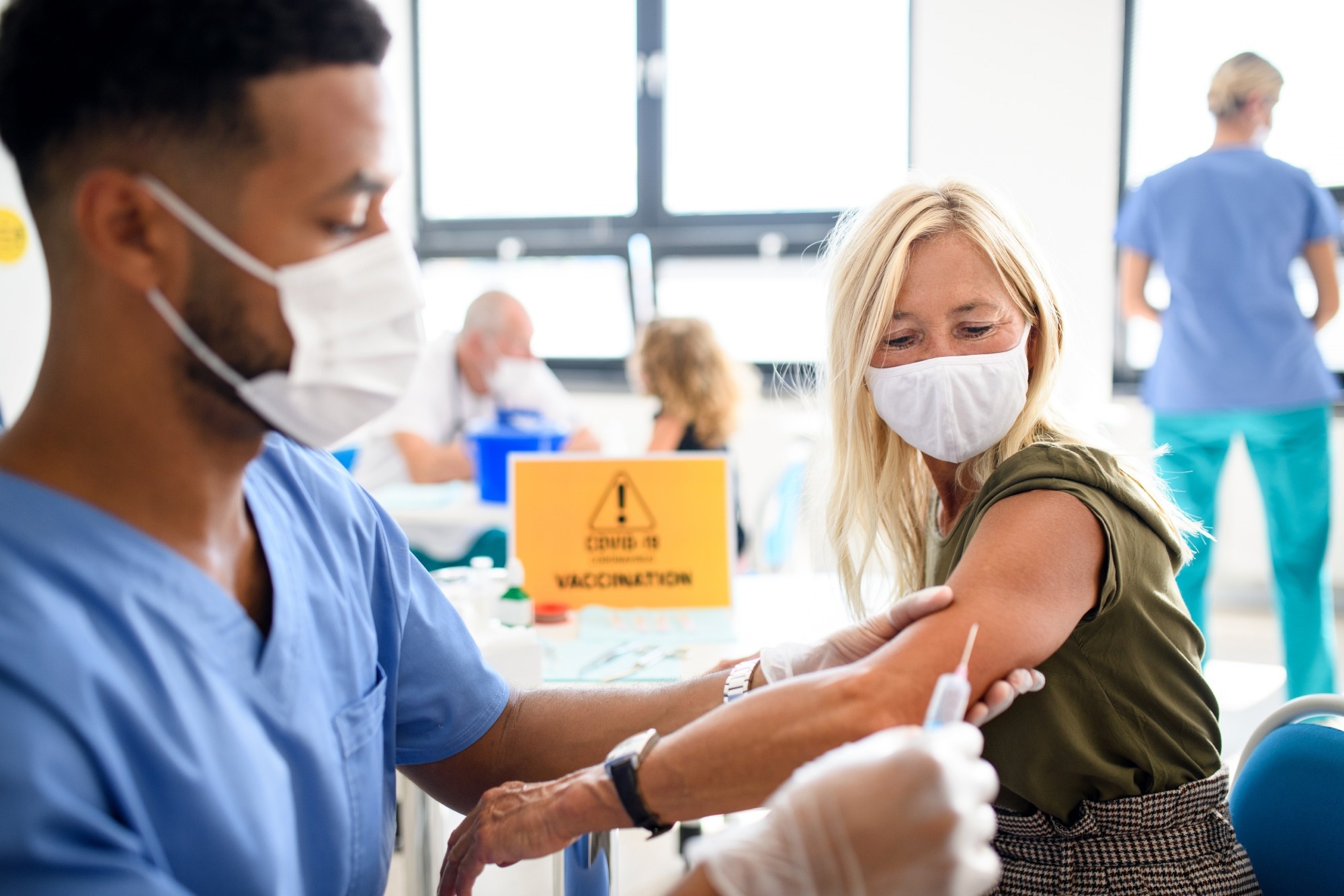 Woman with face mask getting vaccinated
