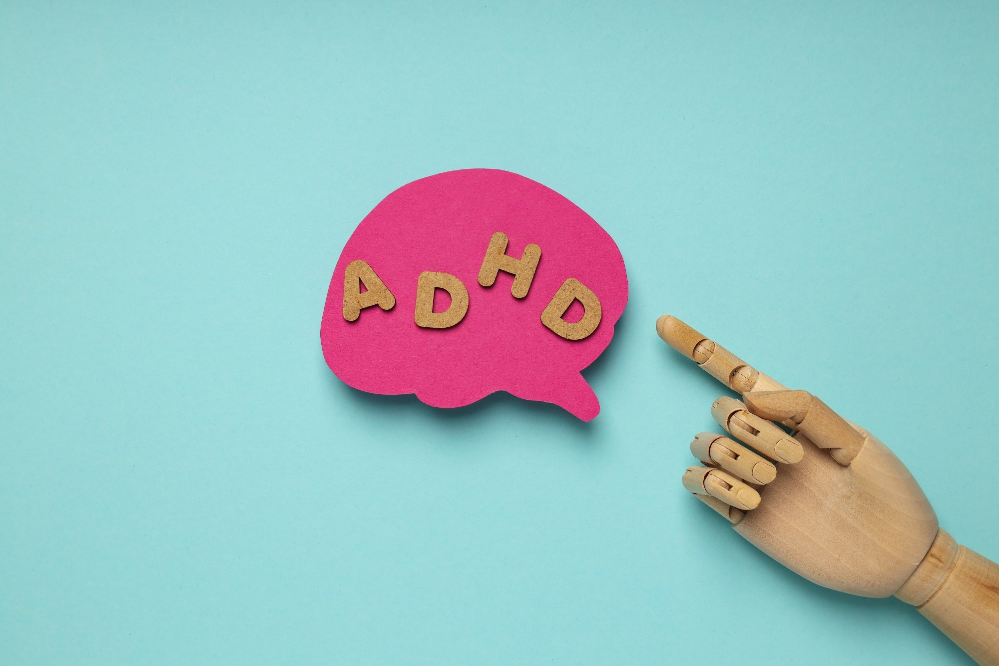 graphic: model hand pointing to brain with letters spelling ADHD within