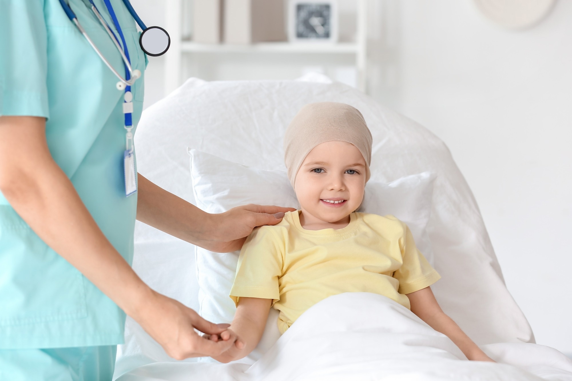Little girl after chemotherapy with nurse lying in clinic