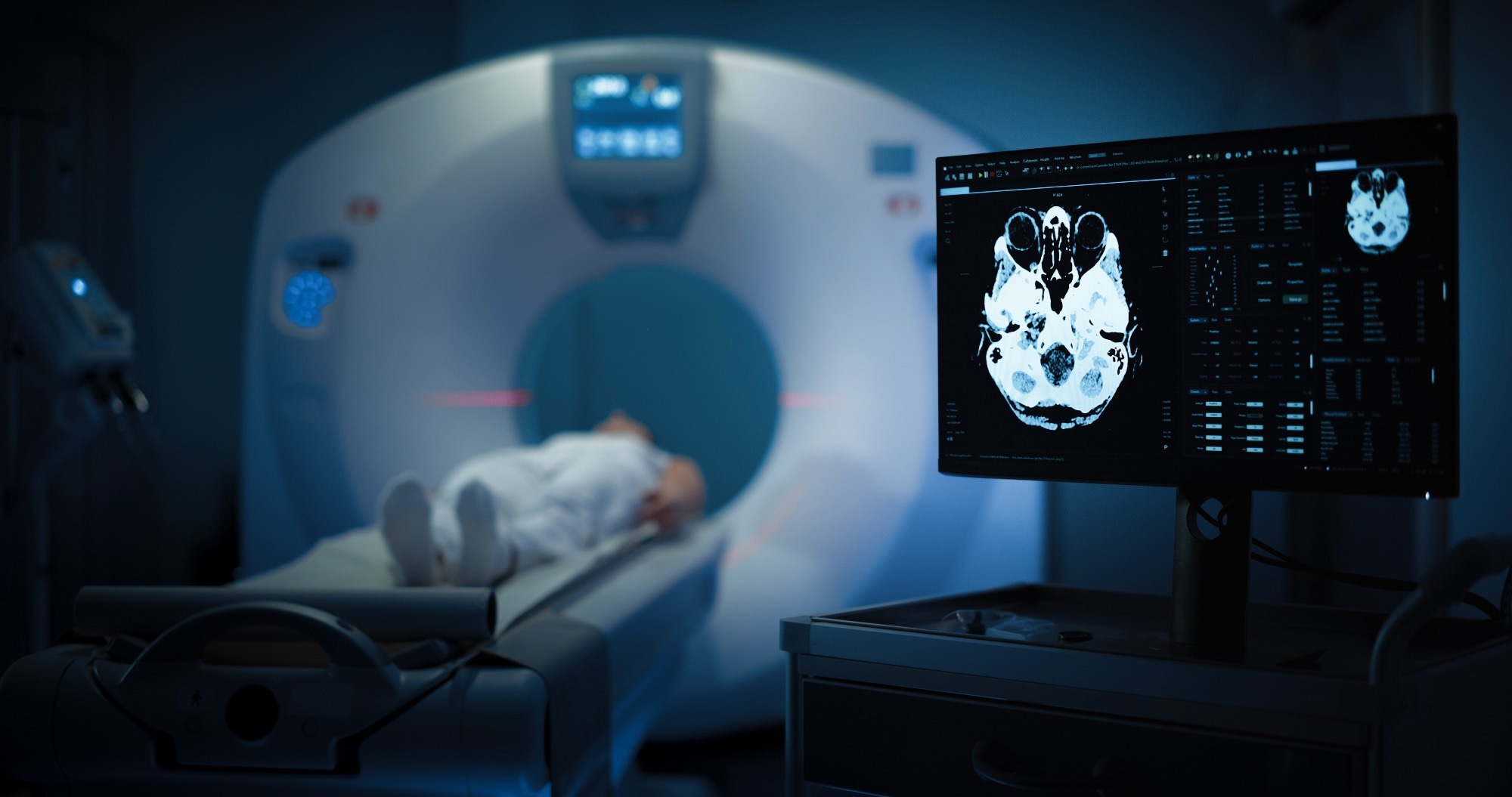 Medium Shot of a Female Patient Lying on a CT or MRI Scan, Bed is Moving Inside the Machine While it Scans her Brain. Display Showing the Results. Footage In Medical Laboratory or Healthcare Facility