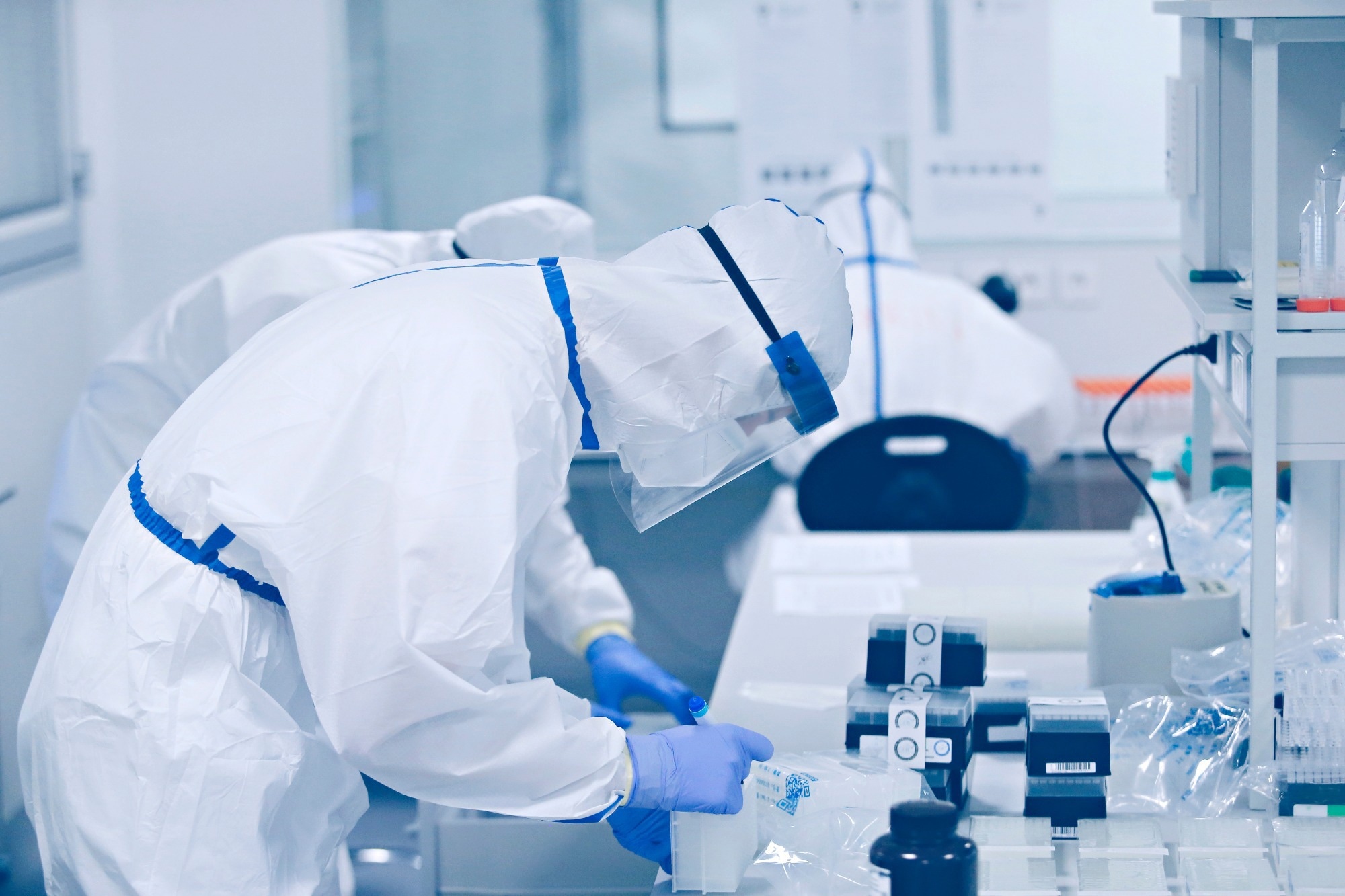 A team of medical scientist working in the lab, wearing ppe suit and face mask in hospital.