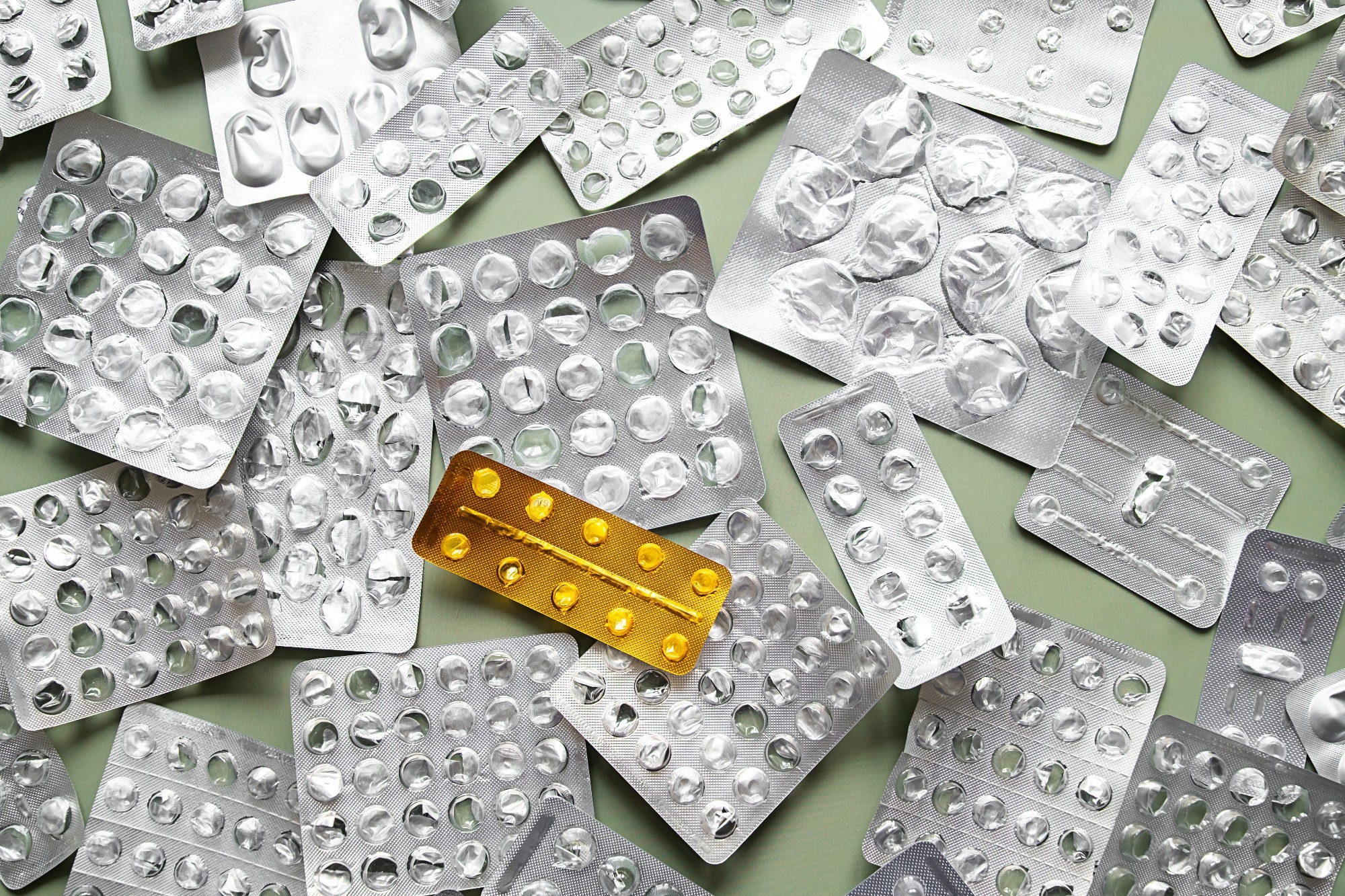 Empty silver blister packs and one gold blister. Medicine scarcity, drug shortage and health crisis concept.