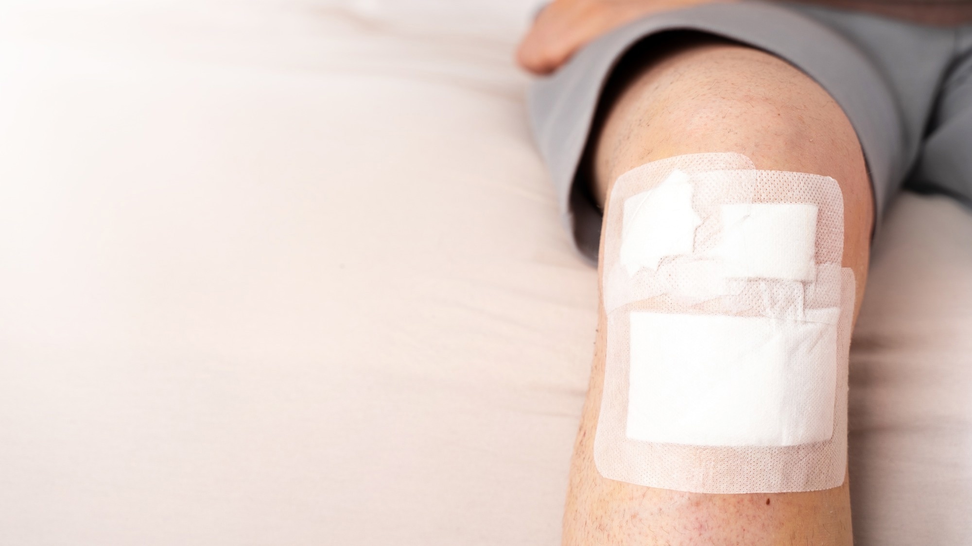 Male leg with adhesive bandage after knee trauma