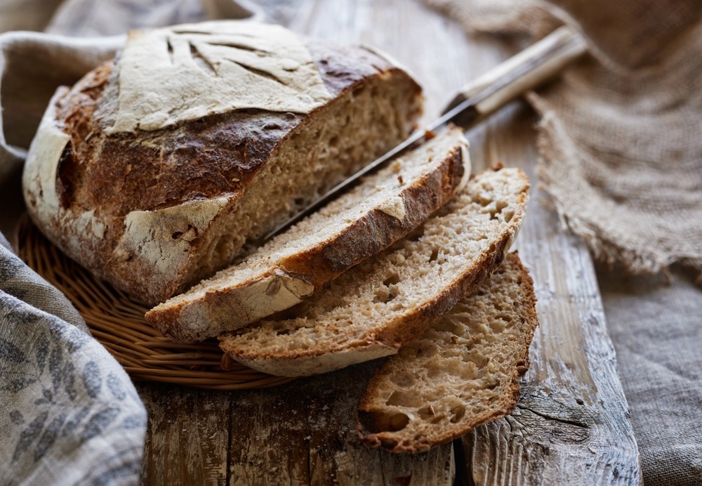 Traditional sourdough bread, sliced on a wooden board, close-up view