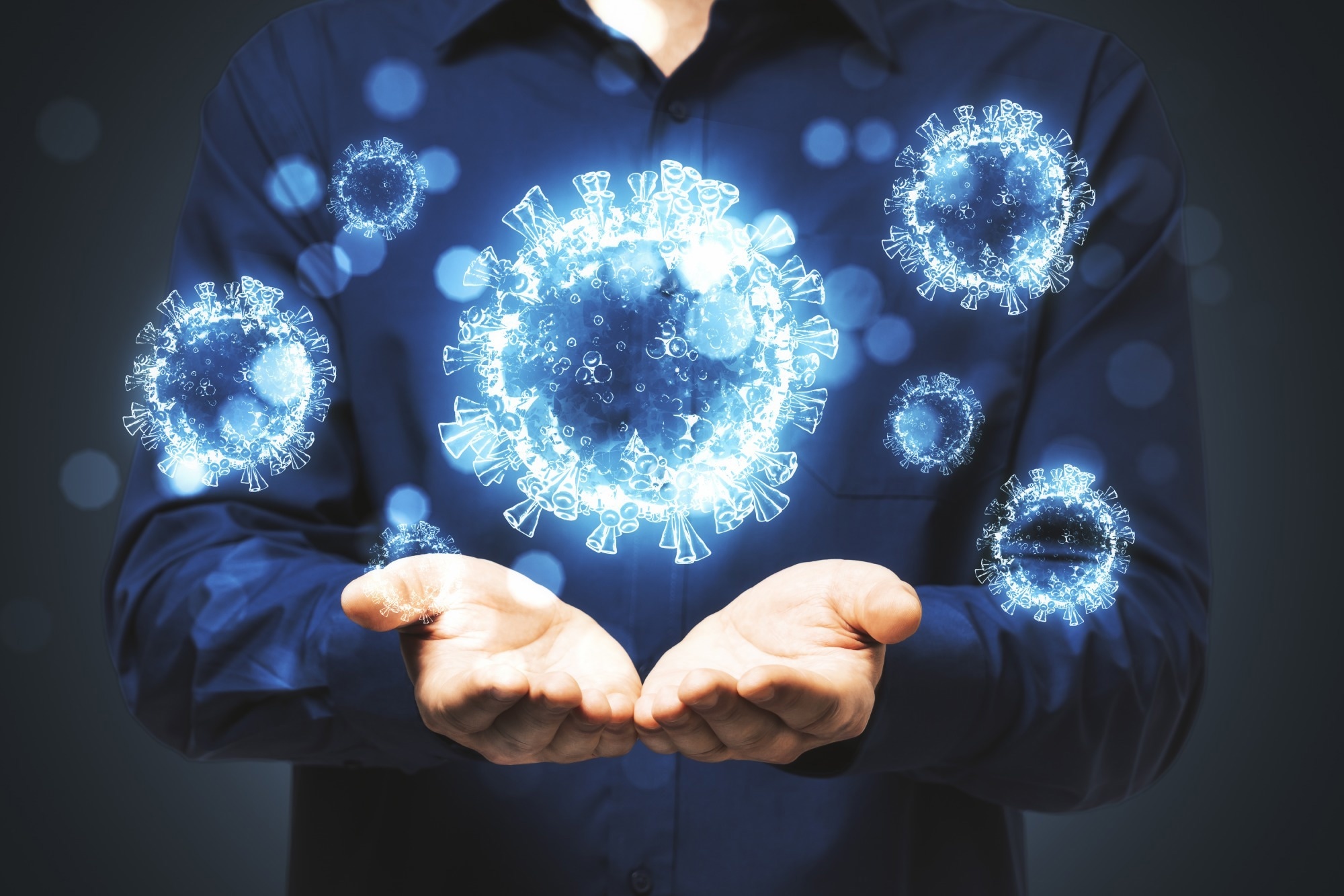 Man holds in his hands blue virus cells. Concept of coronavirus.