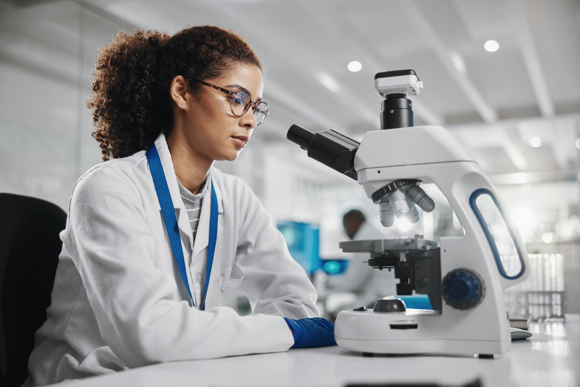 Scientist with microscope in lab