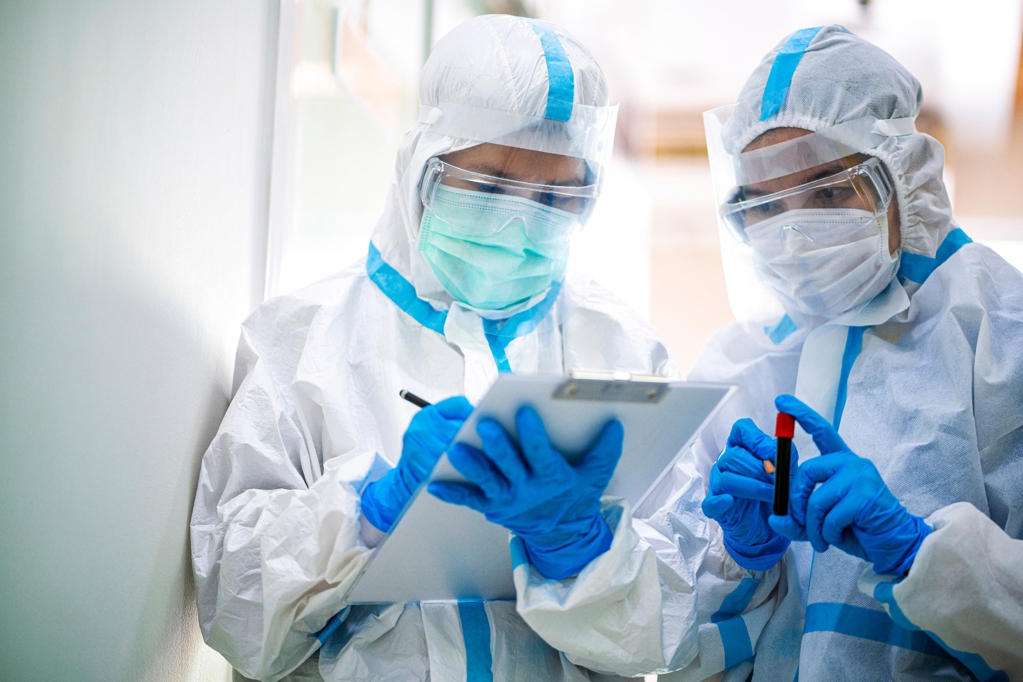 doctor show corona or covid-19 blooding tube wearing ppe suit and face mask in hospital