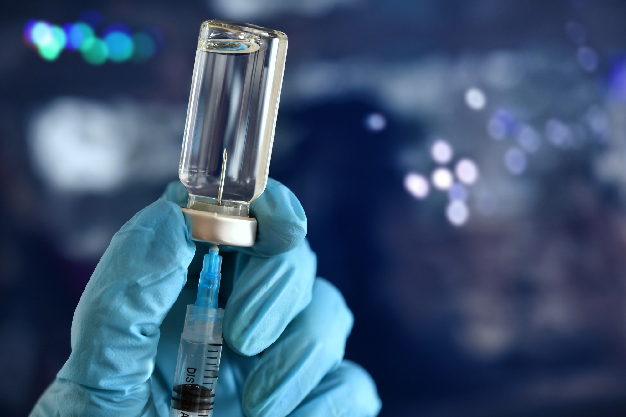 Medical personnel filling a syringe needle